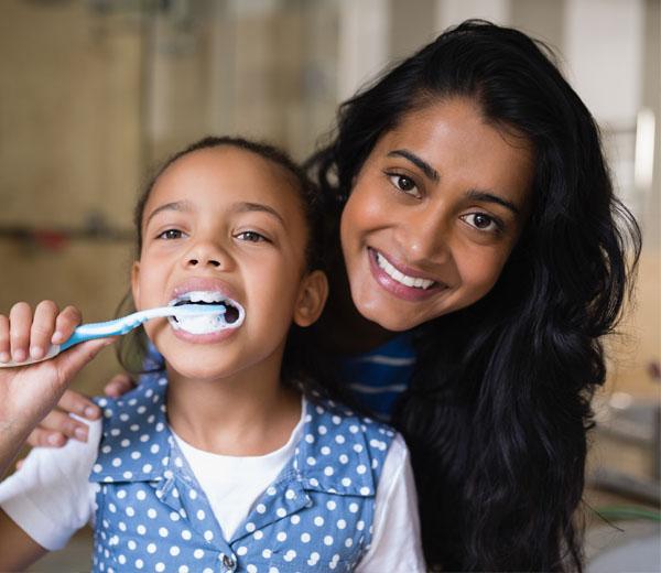 Mother and daughter brushing teeth